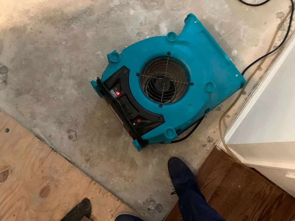 Air mover drying subfloor during Leak Detection & Repair in Lansing